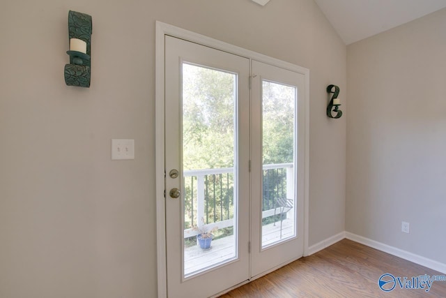 doorway featuring vaulted ceiling and light hardwood / wood-style floors