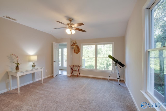 interior space featuring lofted ceiling, plenty of natural light, light colored carpet, and ceiling fan