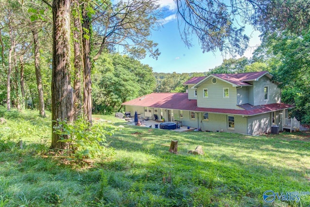 rear view of house with a lawn, central air condition unit, and a patio area