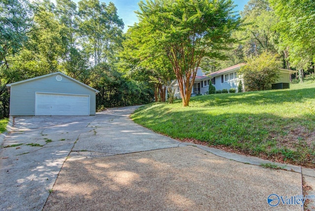 exterior space featuring a garage, an outdoor structure, and a front yard