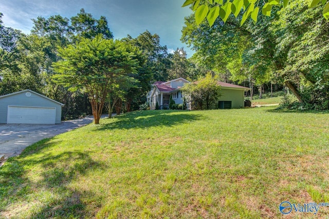 view of yard featuring a garage and an outbuilding