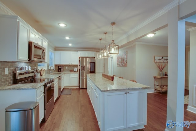 kitchen with sink, decorative light fixtures, a center island, appliances with stainless steel finishes, and white cabinets