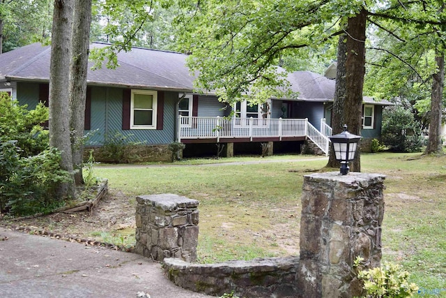 ranch-style house featuring a wooden deck and a front yard