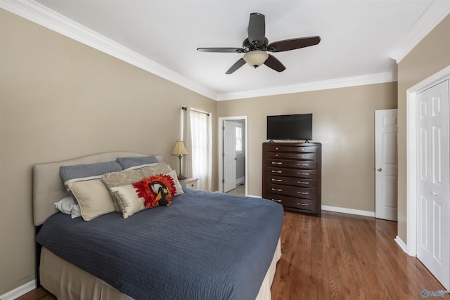 bedroom featuring ceiling fan, crown molding, baseboards, and wood finished floors