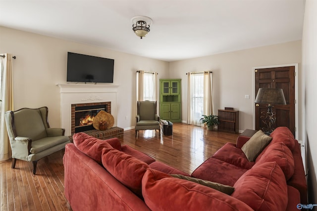 living area featuring hardwood / wood-style flooring, a fireplace, and baseboards