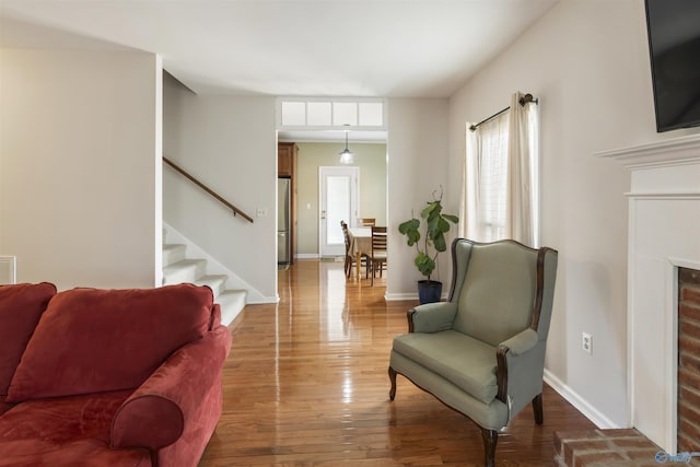 living room with hardwood / wood-style floors, stairway, a fireplace, and baseboards