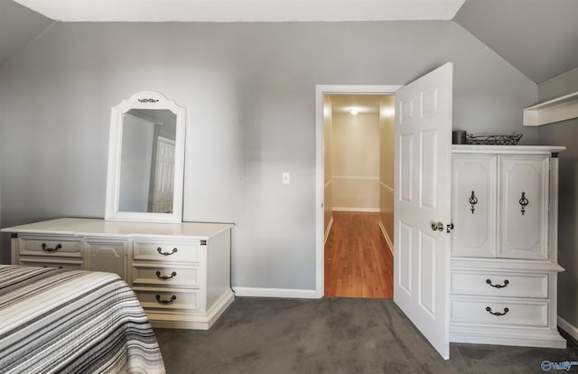 bedroom featuring vaulted ceiling, baseboards, and dark carpet