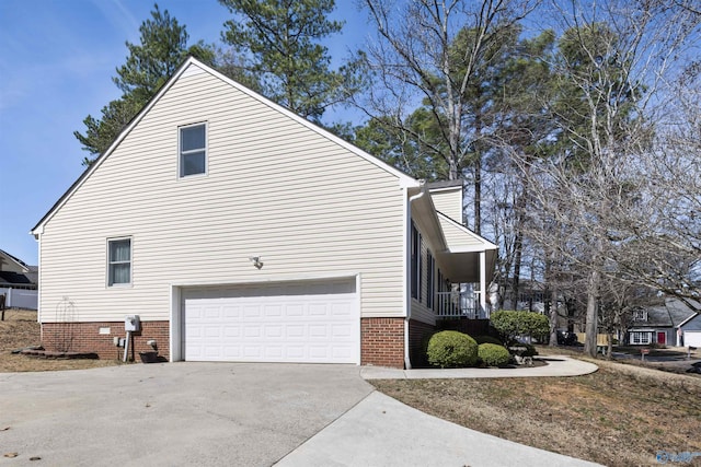 view of property exterior featuring a garage, brick siding, driveway, and crawl space