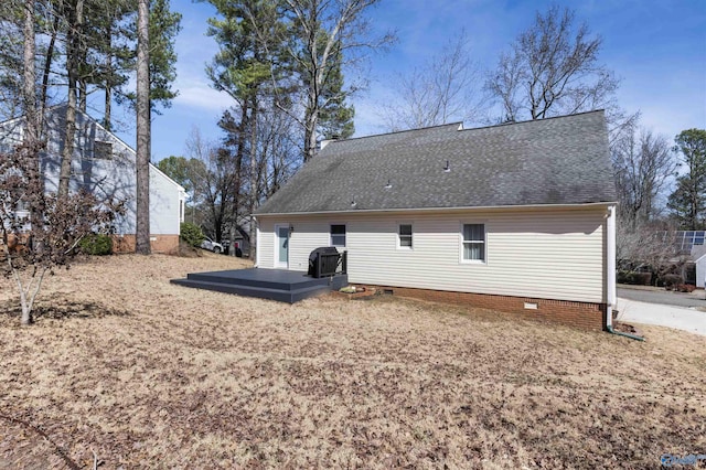 rear view of property featuring crawl space, roof with shingles, and a deck