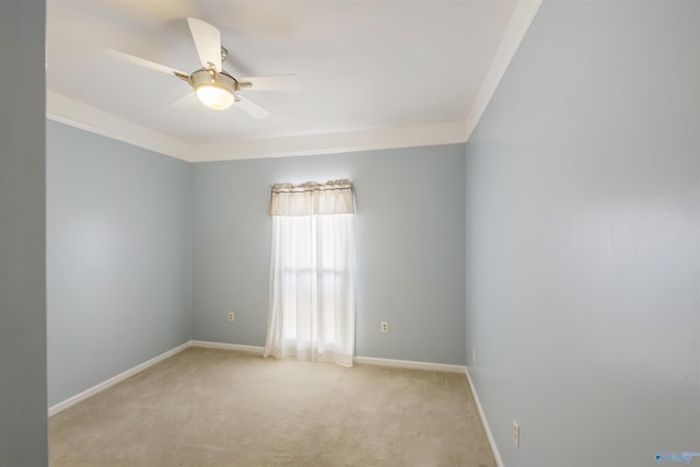 empty room featuring baseboards, light colored carpet, ornamental molding, and a ceiling fan