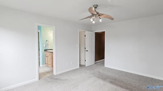 unfurnished bedroom featuring light carpet, ceiling fan, baseboards, and ensuite bathroom