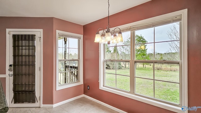 unfurnished dining area with an inviting chandelier, baseboards, a wealth of natural light, and light tile patterned flooring