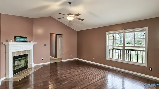 unfurnished living room featuring visible vents, a tiled fireplace, vaulted ceiling, wood finished floors, and baseboards