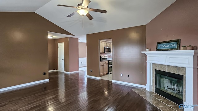 unfurnished living room featuring lofted ceiling, a tile fireplace, wood finished floors, a ceiling fan, and baseboards