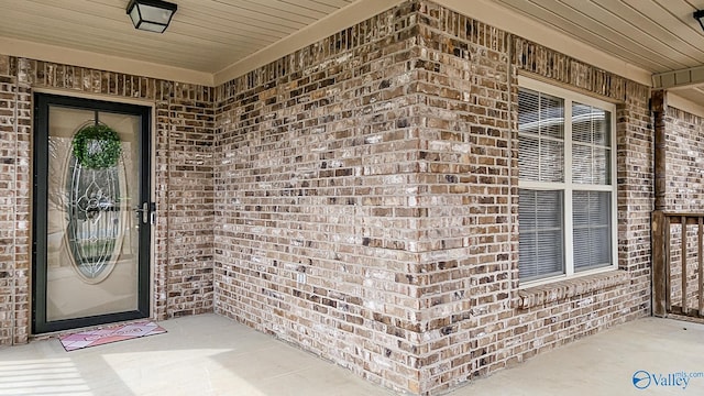 doorway to property with brick siding