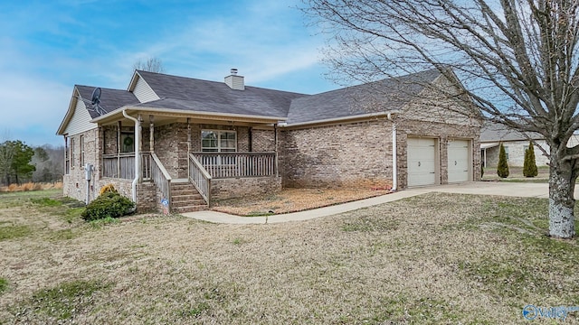 view of front facade with brick siding, a chimney, covered porch, a garage, and driveway