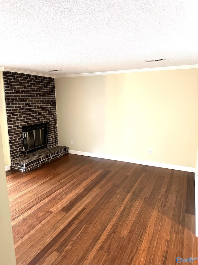 unfurnished living room with hardwood / wood-style floors, a textured ceiling, a brick fireplace, and ornamental molding