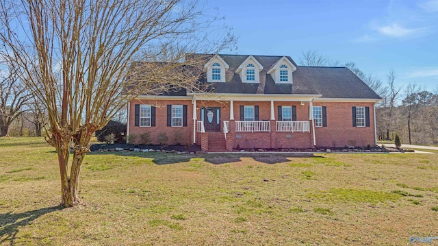 new england style home featuring a front yard and a porch