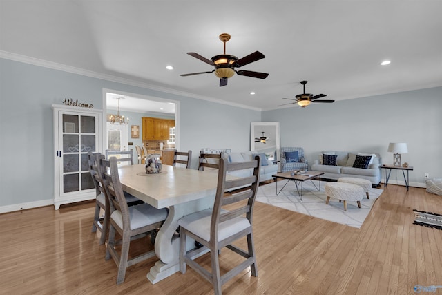 dining room with ornamental molding, light hardwood / wood-style flooring, and ceiling fan with notable chandelier