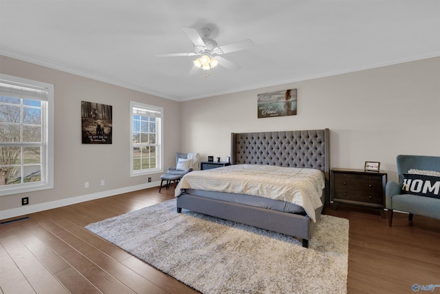 bedroom with dark wood-type flooring, crown molding, and ceiling fan