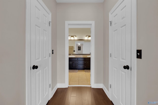 corridor featuring sink and dark wood-type flooring