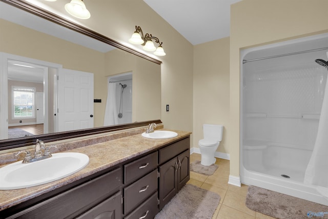 bathroom with tile patterned flooring, vanity, toilet, and walk in shower
