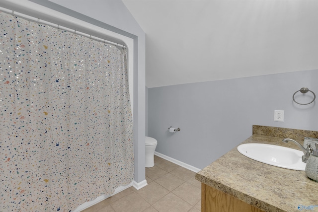 bathroom with vanity, vaulted ceiling, toilet, and tile patterned floors