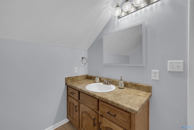 bathroom with tile patterned floors, lofted ceiling, and vanity