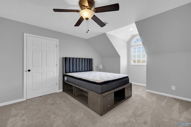 carpeted bedroom with ceiling fan and vaulted ceiling