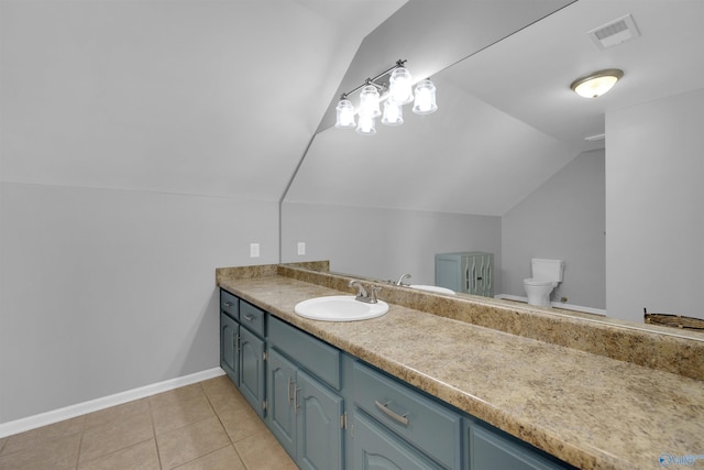 bathroom featuring tile patterned flooring, vanity, toilet, and lofted ceiling