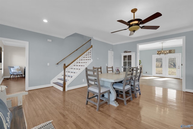 dining space featuring ceiling fan with notable chandelier, light wood-type flooring, french doors, and ornamental molding