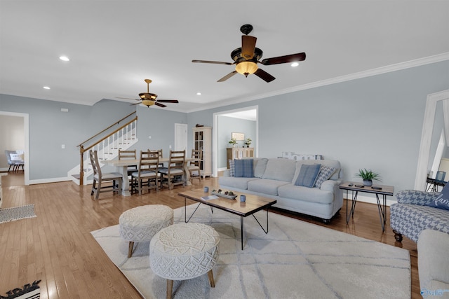living room featuring ceiling fan, light hardwood / wood-style floors, and crown molding