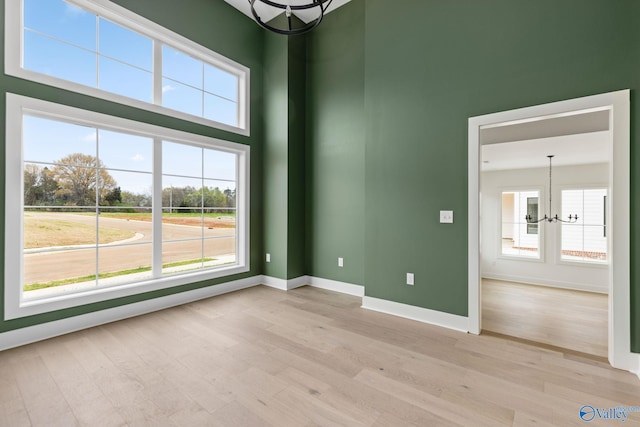 201 Fame Ave, Tuscumbia, AL 35674 - spare room featuring a chandelier, plenty of natural light, and light wood-style flooring