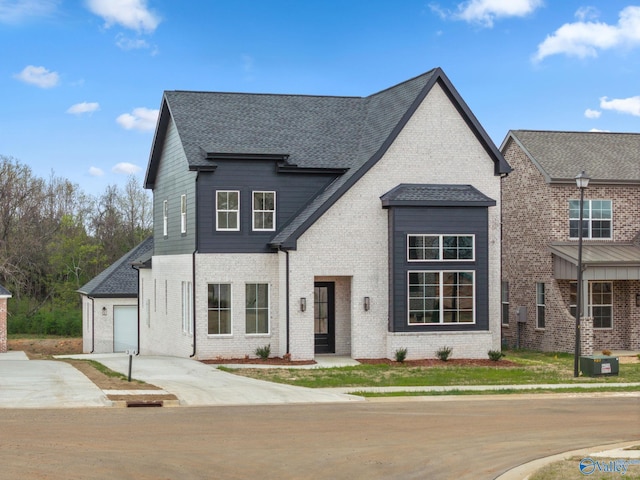 201 Fame Ave, Tuscumbia, AL 35674 - french country style house featuring driveway, roof with shingles, a garage, brick siding, and central AC