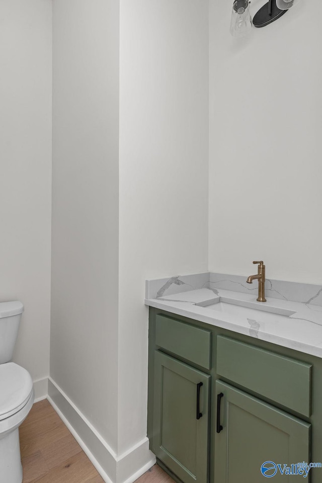 201 Fame Ave, Tuscumbia, AL 35674 - bathroom with vanity, baseboards, toilet, and wood finished floors