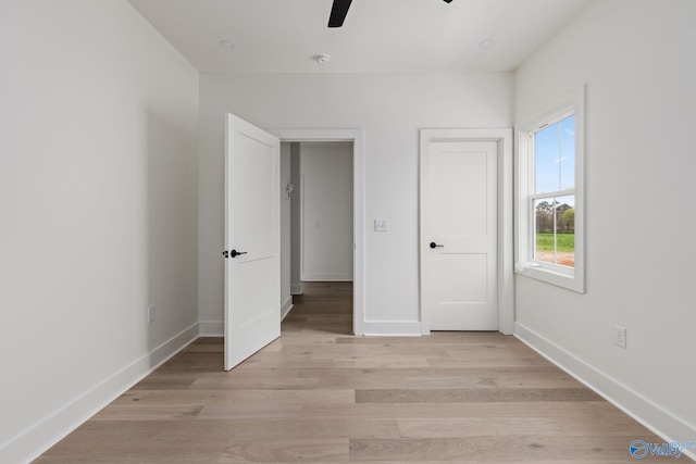 201 Fame Ave, Tuscumbia, AL 35674 - unfurnished bedroom with a ceiling fan, baseboards, and light wood-style flooring