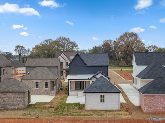 201 Fame Ave, Tuscumbia, AL 35674 - back of house featuring brick siding, a shingled roof, a patio area, and a residential view