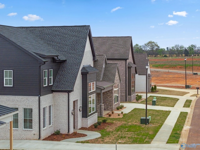 201 Fame Ave, Tuscumbia, AL 35674 - view of front of house featuring central air condition unit, brick siding, and a shingled roof