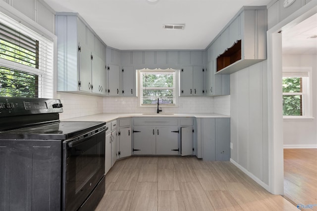 101 Arcade St, Gadsden, AL 35901 - kitchen with black electric range, light countertops, decorative backsplash, gray cabinetry, and light wood-style floors