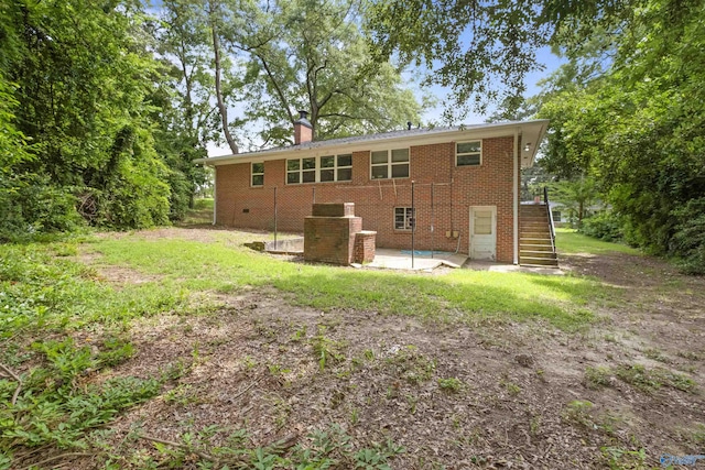 101 Arcade St, Gadsden, AL 35901 - back of house featuring stairs, a chimney, a patio area, and brick siding