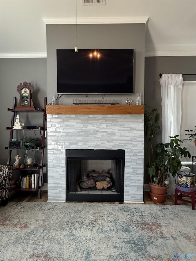 interior details with crown molding, visible vents, and a fireplace