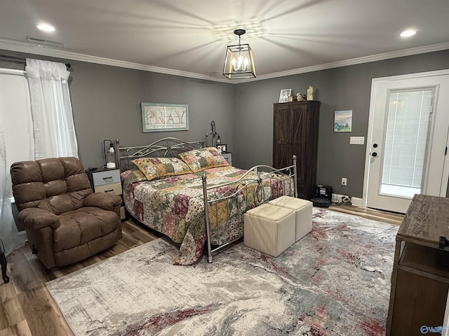 bedroom featuring crown molding, visible vents, and wood finished floors