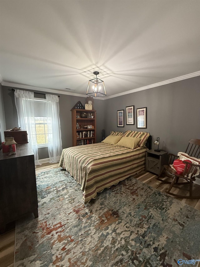 bedroom with crown molding, visible vents, and wood finished floors