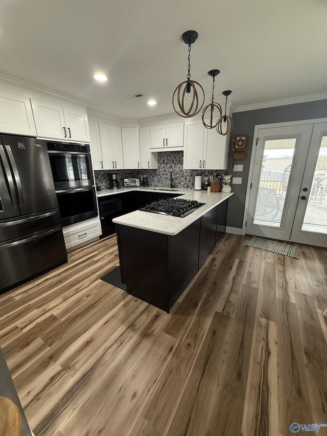 kitchen featuring a peninsula, ornamental molding, freestanding refrigerator, and white cabinetry