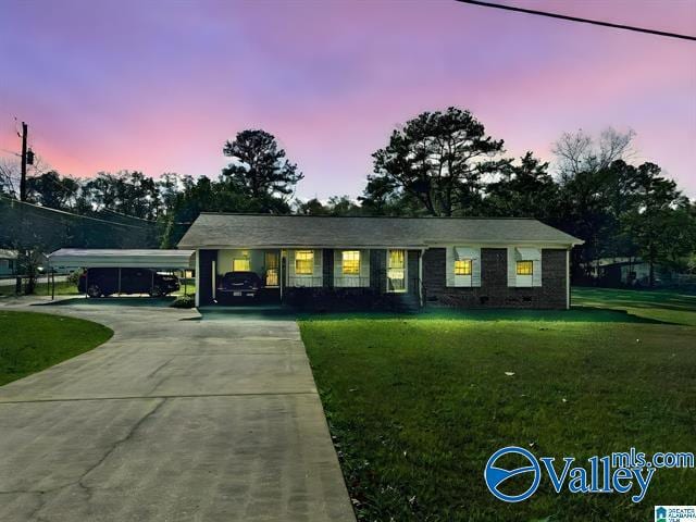 single story home with a yard and a carport