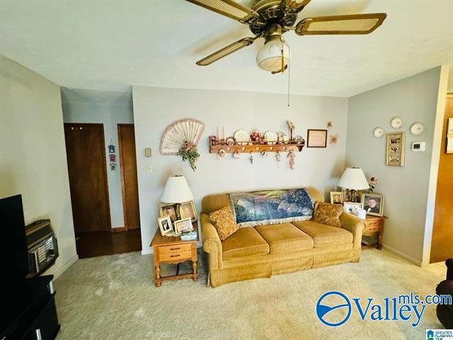 carpeted living room with ceiling fan