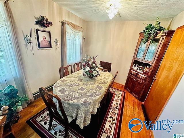 dining room featuring a textured ceiling and hardwood / wood-style flooring