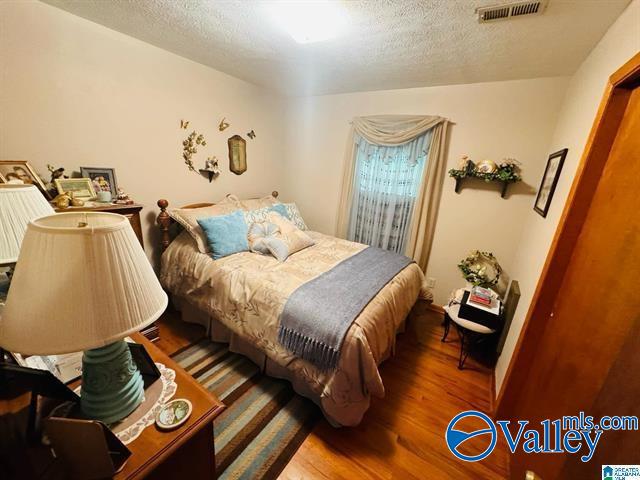 bedroom featuring hardwood / wood-style floors and a textured ceiling