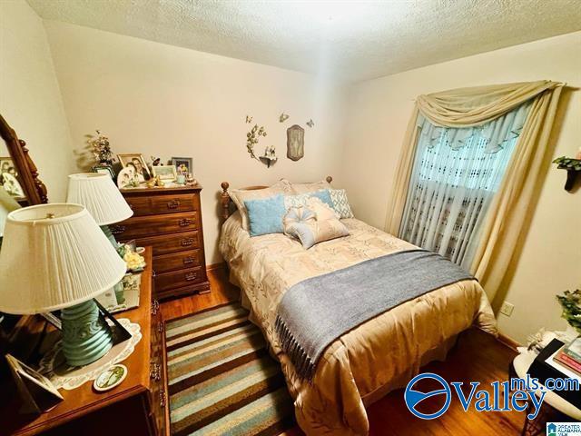 bedroom featuring hardwood / wood-style floors and a textured ceiling