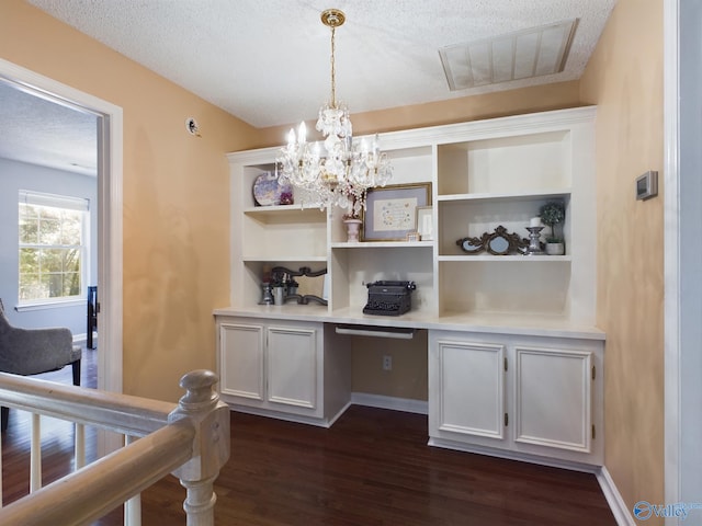 office area featuring a textured ceiling, dark wood-type flooring, and a chandelier